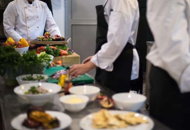 Professionelle Teamköche und Köche bereiten Mahlzeiten in der geschäftigen Hotel- oder Restaurantküche zu