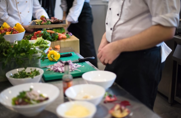 Professionelle Teamköche und Köche bereiten Mahlzeiten in der geschäftigen Hotel- oder Restaurantküche zu