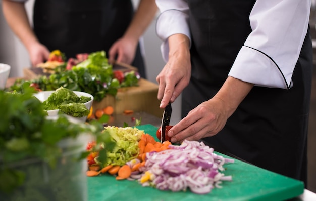 Professionelle Teamköche und Köche bereiten Mahlzeiten in der geschäftigen Hotel- oder Restaurantküche zu