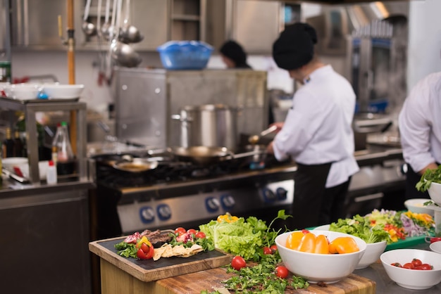 Professionelle Teamköche und Köche bereiten Mahlzeiten in der geschäftigen Hotel- oder Restaurantküche zu