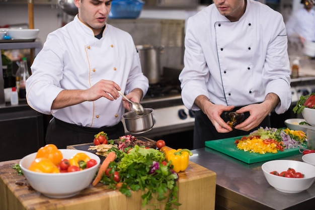 Professionelle Teamköche und Köche bereiten Mahlzeiten in der geschäftigen Hotel- oder Restaurantküche zu