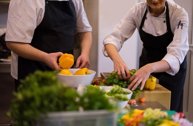 Professionelle Teamköche und Köche bereiten Mahlzeiten in der geschäftigen Hotel- oder Restaurantküche zu