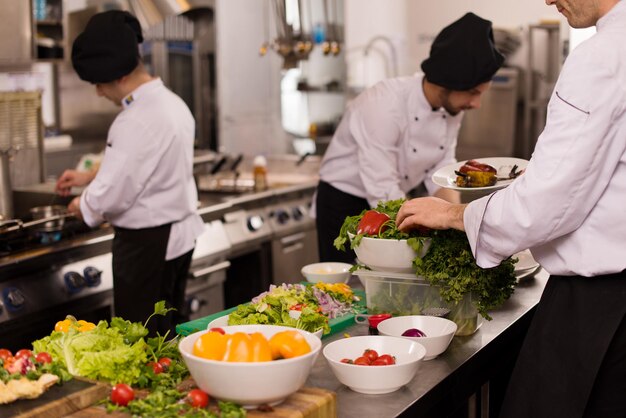 Professionelle Teamköche und Köche bereiten Mahlzeiten in der geschäftigen Hotel- oder Restaurantküche zu