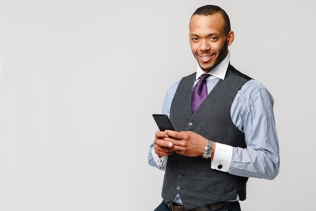 Professioneller afroamerikanischer Geschäftsmann, der Handy hält