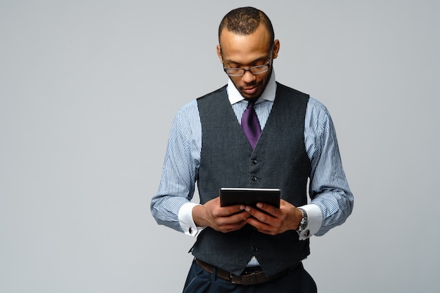 Professioneller afroamerikanischer Geschäftsmann, der Tablett-PC hält.