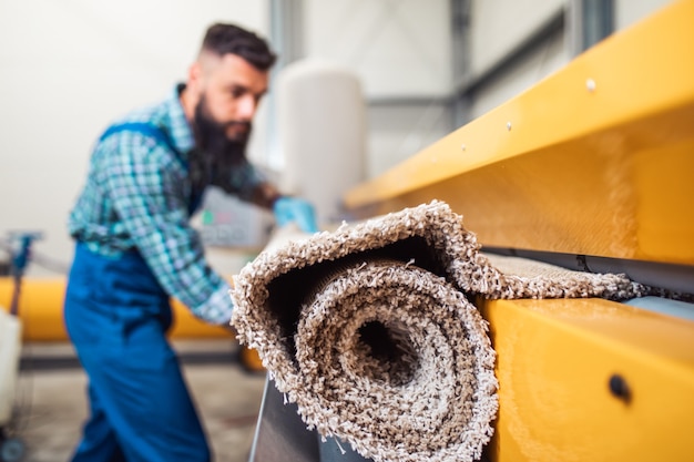 Professioneller Arbeiter, der seine Arbeit beim Teppichwaschservice verrichtet.