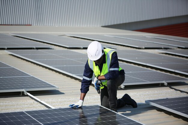 Professioneller Arbeiter, der Sonnenkollektoren auf dem Dach eines Hauses installiert