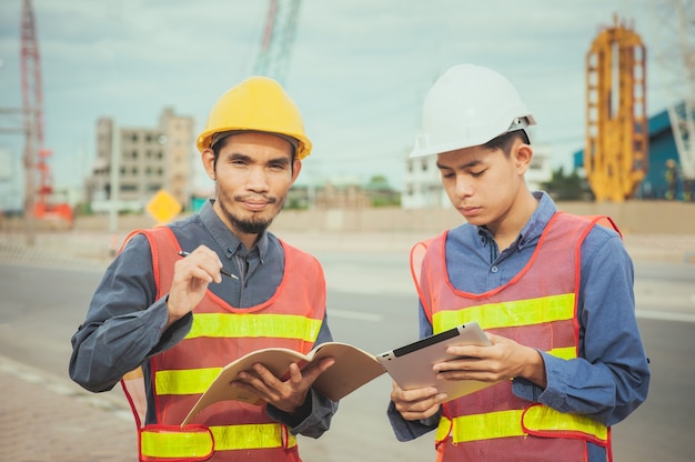 Professioneller Arbeiteringenieur, der durch Tablet-Technologie auf Baustellenarchitekt arbeitet