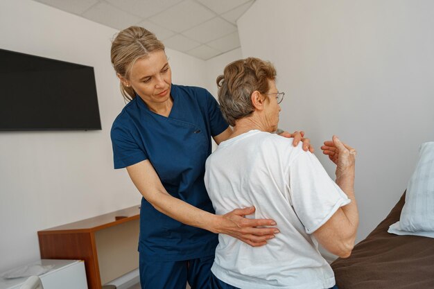 Professioneller Arzt in Uniform untersucht den Patienten während eines Besuchs auf der Krankenstation