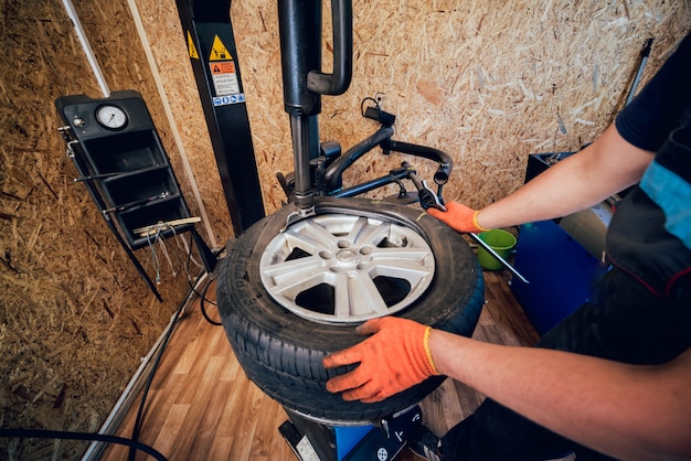 Professioneller Automechaniker Reifen am Rad ersetzen.