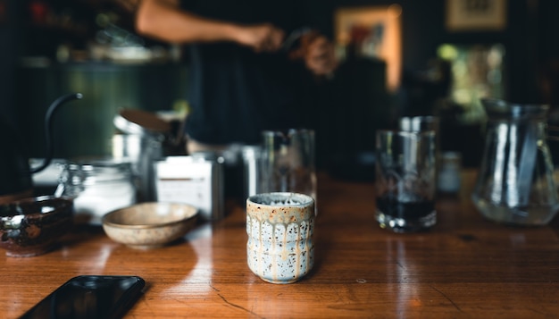 Professioneller Barista, der Kaffee über Kaffeemaschine und Tropfkessel zubereitet drip