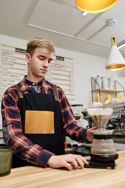 Professioneller Barista-Mann, der Kaffee mit Filter zubereitet