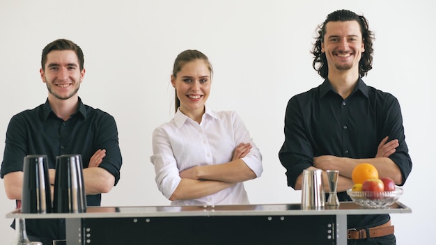 Professioneller Barkeeper Mann und Frau lächelnd am mobilen Bartisch im Studio mit weißem Hintergrund