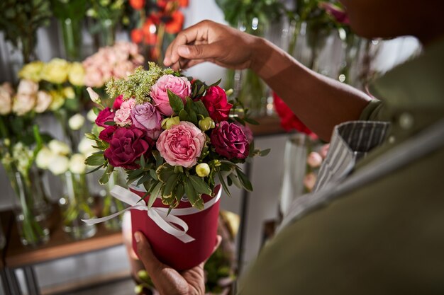 Professioneller Blumendesigner, der ein zusätzliches Blatt von einer perfekten Blumenkomposition wegwirft