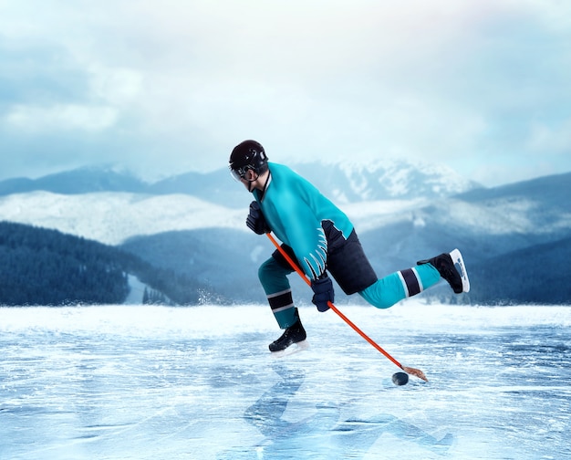 Professioneller Eishockeyspieler in der einheitlichen Übung auf gefrorenem See, Winterwald auf Hintergrund. Eislaufen im Freien