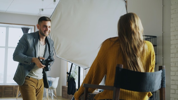 Professioneller Fotograf, der Fotos von Modellen mit einer Digitalkamera macht, die im Fotostudio arbeitet