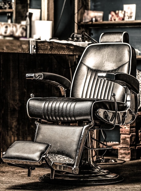 Foto professioneller friseur im barbershop-interieur. friseurstuhl. barbershop-sessel, moderner friseur und friseursalon. bart, bärtiger mann. stilvoller vintage friseurstuhl. schwarz und weiß.