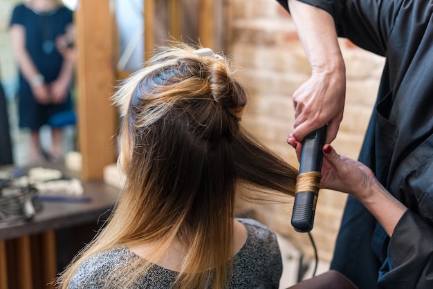 Professioneller Friseur mit Lockenstab