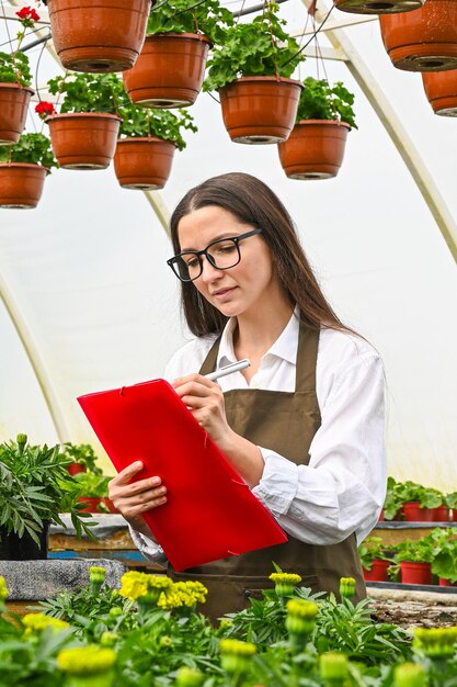 Professioneller Gärtner, der Blumen in einem Gewächshaus produziert