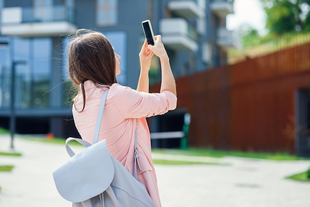 Professioneller Geschäftsfrau-Architekt fotografiert auf dem Smartphone im Bau eines neuen Projektgebiets von