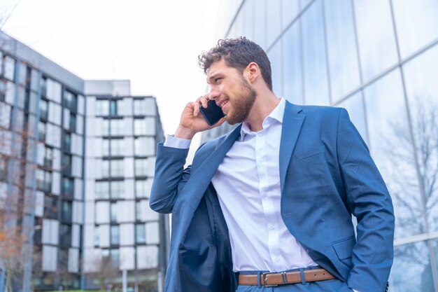 Professioneller Geschäftsmann eines Unternehmens außerhalb des Büros, der einen Arbeitsanruf tätigt