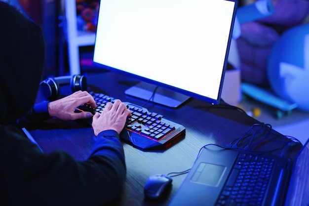 Professioneller Hacker mit Computer im dunklen Raum