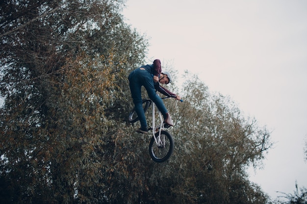 Professioneller junger Sportler mit BMX-Fahrrad im Skatepark