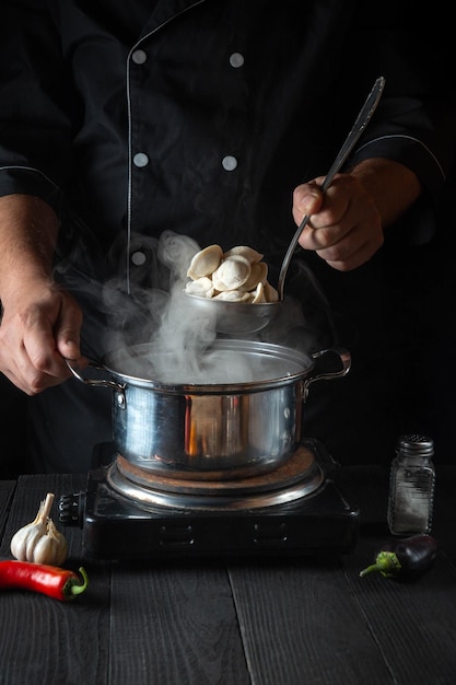 Professioneller Koch kocht Fleischknödel in einem Topf in der Restaurantküche
