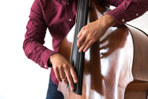 Professioneller Kontrabassist. Fotoshooting im Studio. Weiß