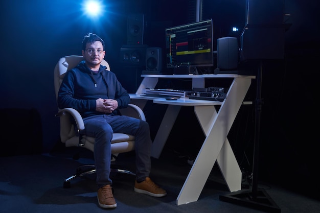 Professioneller männlicher Toningenieur, der Audio im Tonstudio mischt Musikproduktionstechnologie, die am Mixer arbeitet