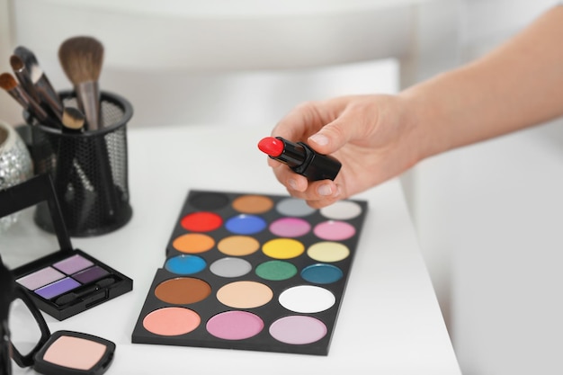 Professioneller Make-up-Künstler mit Kosmetik im Schönheitssalon