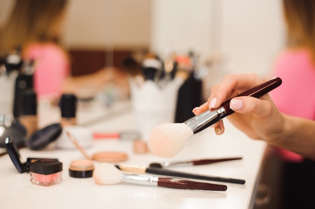 Professioneller Make-up Pinsel in den Händen des Stylisten