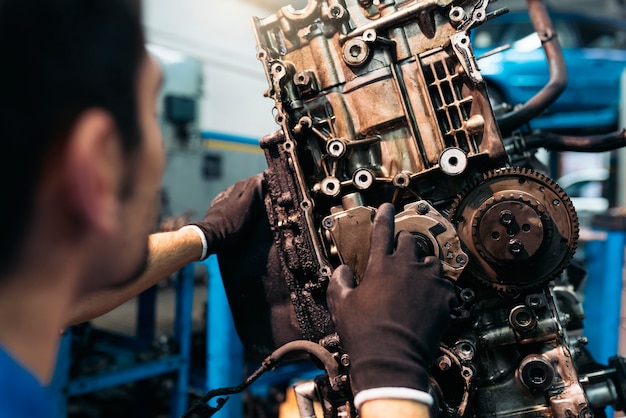 Professioneller Mechaniker, der Automotor in der Garage repariert.