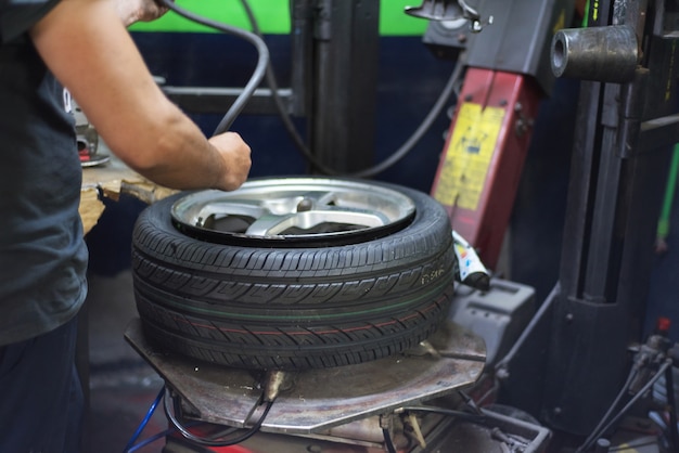 Professioneller Mechaniker, der Maschine für Reifenwechsel verwendet.