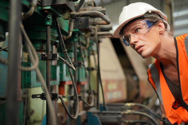 Professioneller Metallarbeiter, der CNC-Fräsmaschinen in der Fertigungswerkstatt betreibt