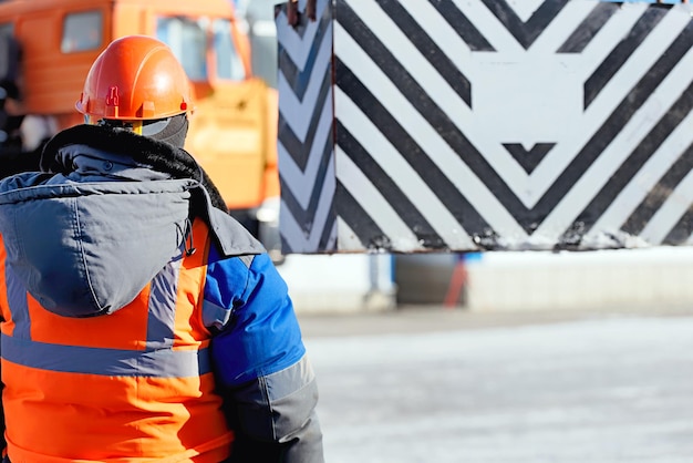 Professioneller Schleuderer im Bauhelm im Werk entlädt Fracht Ladetraining