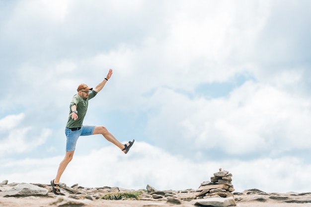 Professioneller Sporstman, der im Freien an der Natur vorwärts springt. Trittsteine für Reisende.