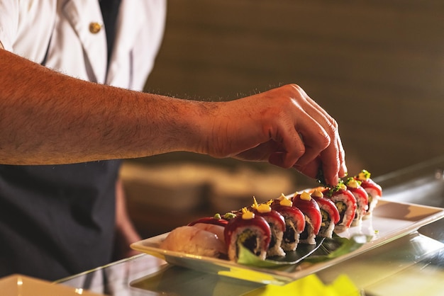 Professioneller Sushi-Koch, der Sushi-Rollen dekoriert