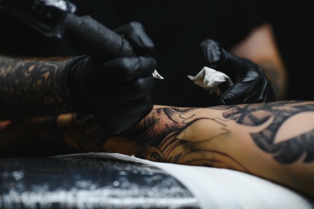 Professioneller Tätowierer, der in seinem Tattoo-Studio arbeitet.