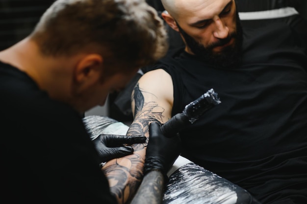 Professioneller Tätowierer, der in seinem Tattoo-Studio arbeitet.