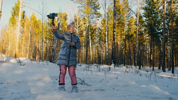 Professioneller Videofilmer, der im Winter eine DSLR-Kamera auf einem 3-Achsen-Gimbal-Stabilisierungsgerät hält. Kameramann Operator. Zeitlupe