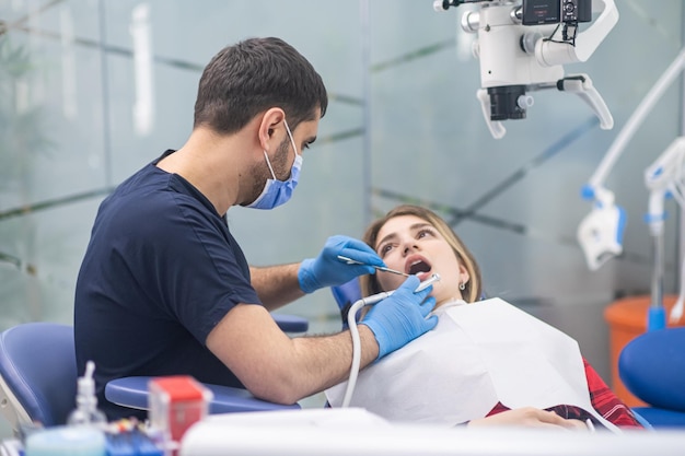 Professioneller Zahnarzt in medizinischer Maske, der den Zustand von Zähnen und Hohlraum überprüft