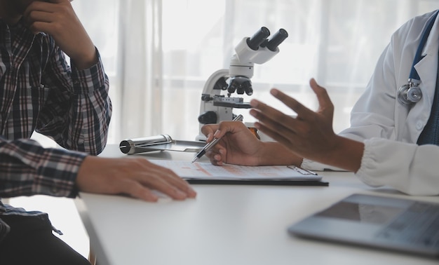 Professionelles Labor Erstaunlicher langhaariger medizinischer Mitarbeiter in Uniform, während er während der Forschung das Mikroskop benutzt