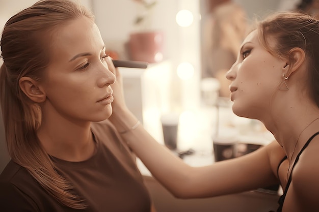 professionelles Make-up im Schönheitssalon / Master macht ein professionelles frisches Sommer-Make-up eines schönen Models im Salon