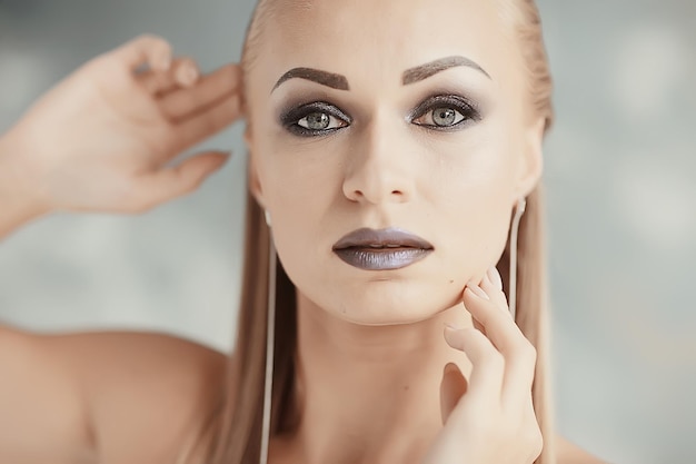 Professionelles Make-up-Model-Studio / Model posiert im Studio mit hellem, frischem Make-up, schönen Augen und Lippen mit Make-up