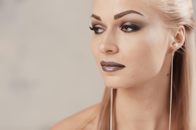 Professionelles Make-up-Model-Studio / Model posiert im Studio mit hellem, frischem Make-up, schönen Augen und Lippen mit Make-up