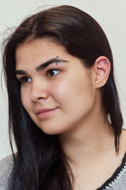 Professionelles Platzieren des Juwels des Piercings auf der Schläfe auf dem Kopf mit Kugeltragus-Typ