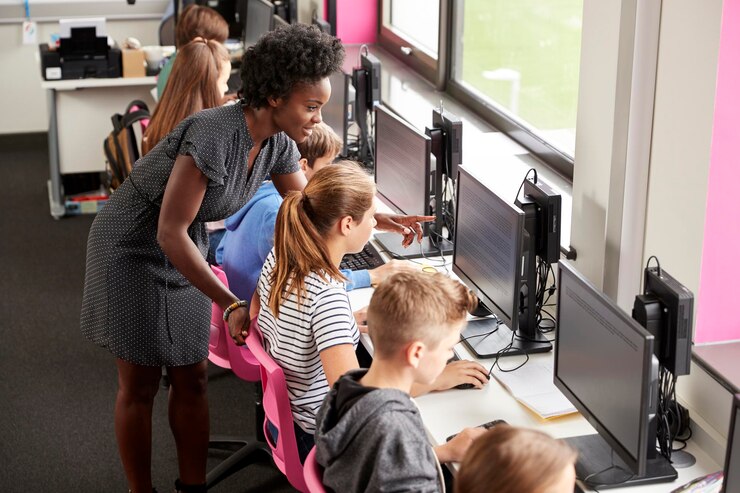 Foto professor ajudando a linha de alunas de alunos do ensino médio trabalhando em telas na aula de computador