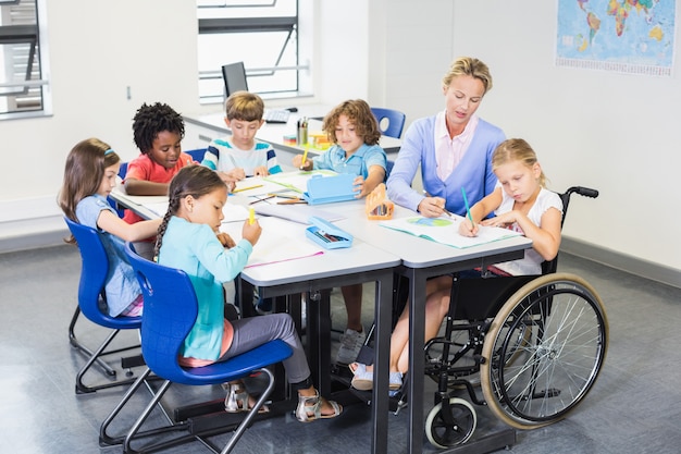 Foto professor, ajudando as crianças com os trabalhos de casa na sala de aula