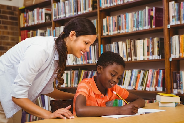 Professor, ajudando, menino, com, dever casa, em, biblioteca